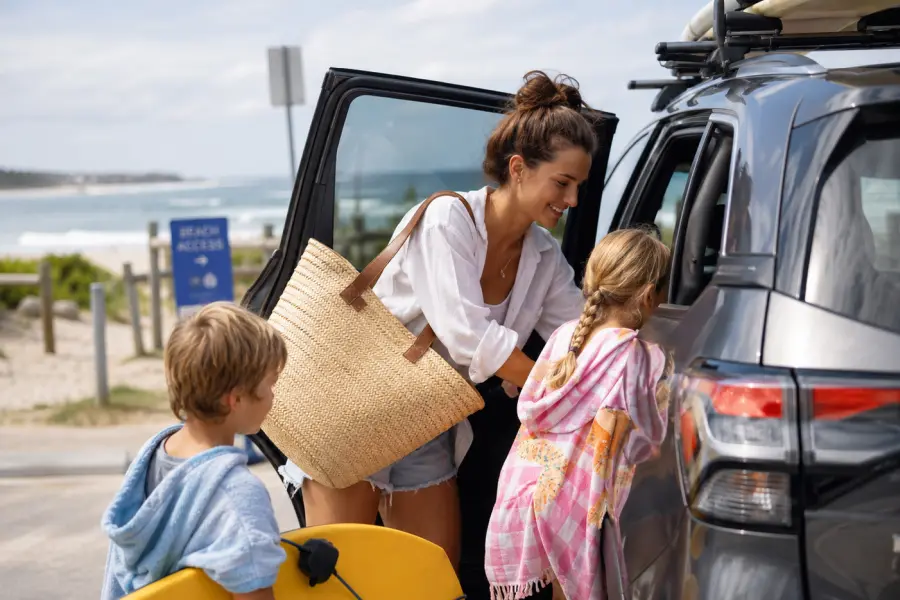 Au Pair loading car with Children in Australia at the beach